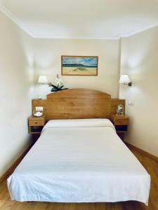 波多诺伏Hostal Casa Isabel的一间卧室配有一张带2个床头柜的大型白色床