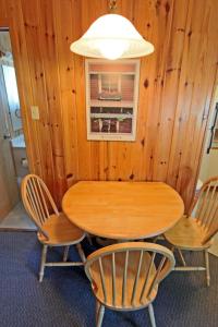 亨茨维尔殖民湾别墅汽车旅馆 的木制餐桌、椅子和灯