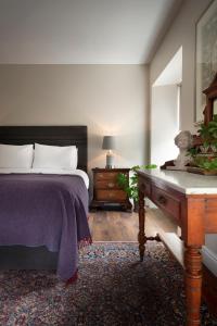 肯梅尔Bridge Street Townhouse的一间卧室配有一张床和一张木桌