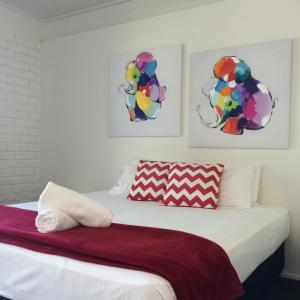 阿卡狄亚阿卡迪亚村莫泰酒店的卧室配有一张壁画和两张画的床铺。