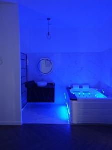 佩皮尼昂Suite Miro Charme et volupté的蓝色的客房设有浴缸和水槽