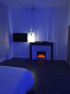 佩皮尼昂Suite Miro Charme et volupté的蓝色的客房设有壁炉和床。