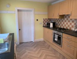 福尔柯克Grangemouth Apartments的厨房配有水槽和炉灶 顶部烤箱