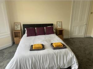 福尔柯克Grangemouth Apartments的一间卧室配有一张床,上面有两条毛巾