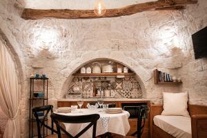 洛科罗通多LiberaMente - Trulli & Quiete的一间石墙内带桌子的用餐室