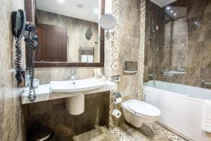 波亚纳布拉索夫Alpin Resort Hotel - Apartamentele 2403-2404- proprietate administrata de gazda privata的浴室配有盥洗盆、卫生间和浴缸。