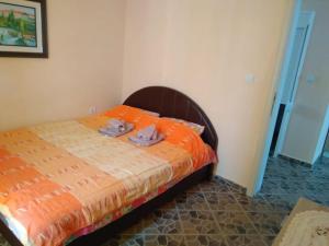 尤塔哈MonoLiza的一间卧室配有一张带橙色棉被的床