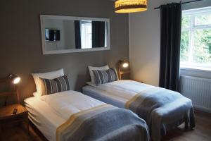 Granastaðir格兰艾斯陶住宿加早餐旅馆的卧室设有两张床铺、镜子和窗户