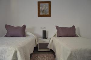 贝尼曼特利CASA CARAVINA的两张睡床彼此相邻,位于一个房间里