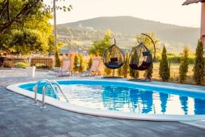 比哈奇Villa Una Dalia的一个带椅子和秋千的游泳池