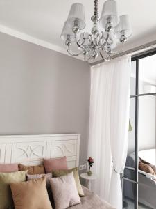 丰坦卡Luxury Apartments Park Fontanov的一间卧室配有吊灯和一张带枕头的床