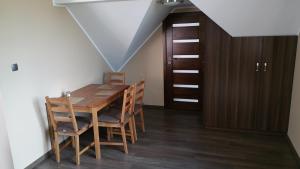 格但斯克Zacisze的一间带木桌和椅子的用餐室