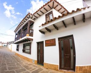 莱瓦镇Nibiru Hostel的白色的建筑,设有棕色的门和阳台