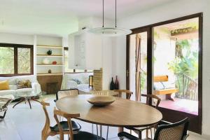 罗达德瓦拉Casa mediterránea con gran jardín y piscina a 500 m de la playa的客厅配有木桌和椅子