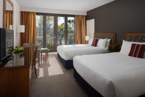 Wonga Park亚拉河谷旅舍的酒店客房设有两张床和电视。