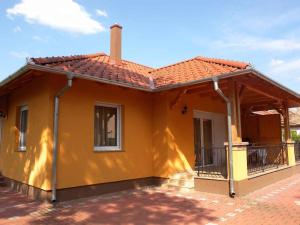 鲍洛通凯赖斯图尔Holiday Home Balatonmariafurdo, Somogy 1的黄色的房屋,有红色的屋顶
