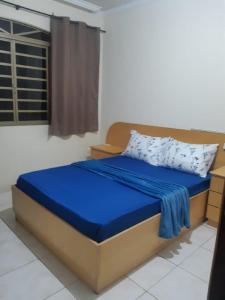 马林加Cascais Hostels Quartos & Suítes的一间卧室配有一张带蓝色床单的床和一扇窗户。