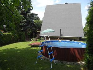 Bludov斯蒂波克拉西1号度假屋的庭院内的热水浴池,配有遮阳伞