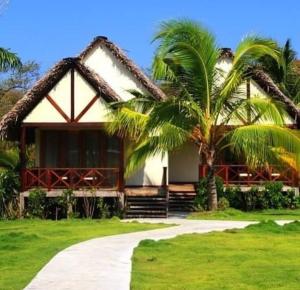 普拉纳维瑙维瑙海滩度假酒店的前面有棕榈树的房子