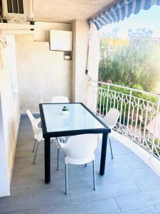 圣波拉Apartamento Santa Pola"The Guitar" 300 m de la playa的阳台上配有一张黑桌和白色椅子