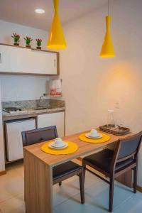 坎普斯戈伊塔卡济斯Flat Completo para uma estadia perfeita NOTA FISCAL的厨房配有木桌、椅子和黄色灯