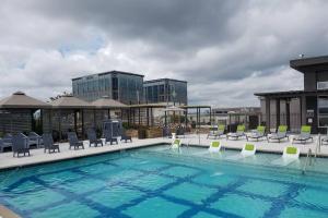 亚特兰大Buckhead Blue - Spacious 2 bd 2ba - Private Balcony-Rooftop- S13的一座带椅子的大型游泳池和一座建筑