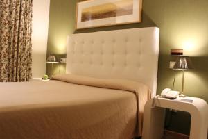 里瓦德奥博萨酒店的一间酒店客房,配有一张床铺和一张桌子上的电话