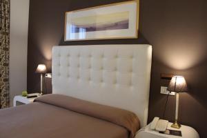 里瓦德奥博萨酒店的卧室配有一张床,墙上挂着一幅画