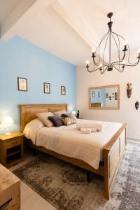 AtellaPalazzo Badiale history&rooms的一间卧室配有一张大床和一个吊灯。
