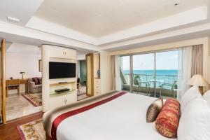 南芭堤雅Royal Wing Suites & Spa Pattaya的一间卧室设有一张大床,享有海景