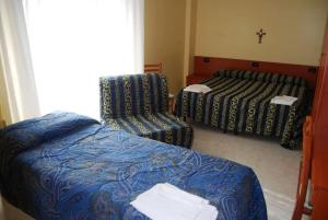 圣乔瓦尼·罗通多Hotel Il Chierichetto的酒店客房,配有两张床和椅子