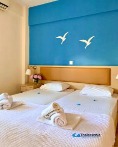 卡尼奥提塔拉塞尼亚公寓酒店的两张位于酒店客房的床,配有毛巾