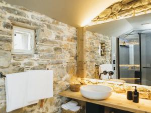 门德里西奥Locanda San Silvestro - Meride的一间带水槽和石墙的浴室