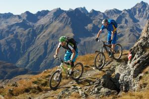 伊施格尔Gasthof Alt Paznaun的两人骑着自行车在山间小径上