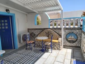 佩里沃罗Stavros Beach Villas的墙上设有带桌椅的天井。