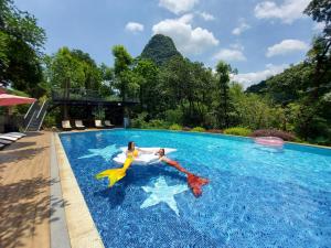 阳朔阳朔水岸花园江景酒店的两个人在游泳池玩耍
