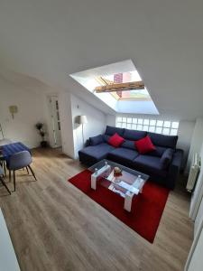 埃拉斯蒂列罗Apartamento nuevo en El Astillero的客厅配有蓝色的沙发和红色地毯。