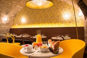 巴黎快乐文化约瑟芬酒店的用餐室配有餐桌和食物