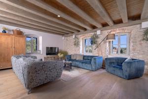 Veliko GrabljeVilla Zanino的客厅配有2张蓝色沙发和电视