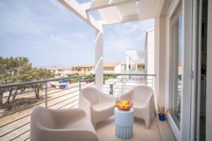 罗萨岛MERMAID'S HOUSE的阳台配有白色椅子,享有海景。