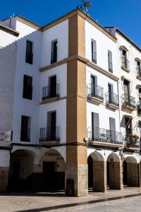 卡塞雷斯Apartamentos El Patio Plaza Mayor Cáceres的前面有拱门的白色建筑