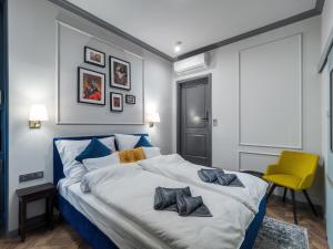 布达佩斯A22 Boutique Suites的一间卧室配有一张大床和黄色椅子