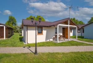 达尔沃沃Ranczo nad morzem的院子内带野餐桌的白色小房子