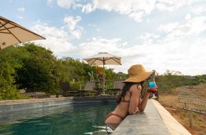格拉罕镇帕姆巴私人野生动物保护区酒店的坐在游泳池旁的比基尼的女人