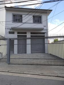圣保罗Pousada Monte Alegre的白色的房子,设有两个车库门和围栏