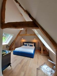 Putot-en-AugeChâteau de la Bribourdière的阁楼卧室配有蓝色床