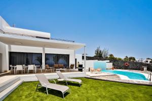 普拉亚布兰卡Marblau Lanzarote的一个带游泳池和草地的后院