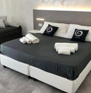 圣玛丽亚德尔西德Sesto Senso Home的一张大床,配有黑白床单和毛巾