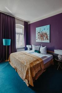 德累斯顿Boutique Hotel Rothenburger Hof的一间卧室设有一张紫色墙壁的大床
