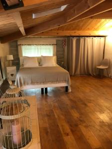 塞雷斯特La Charmeuse的一间卧室配有一张床,铺有木地板